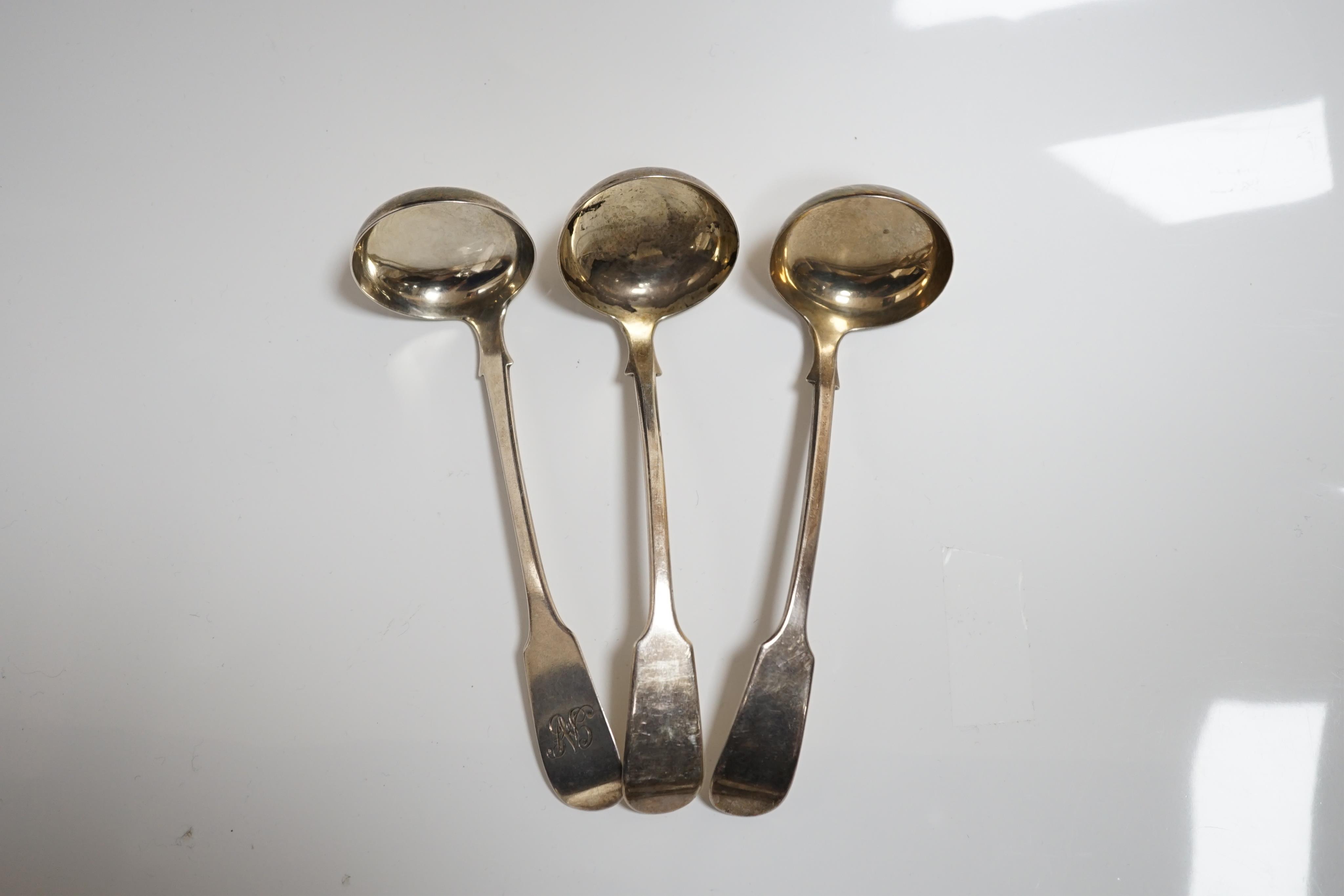 A pair of Victorian silver fiddle pattern sauce ladles, James Wright, Edinburgh, 1862, 15cm, and one other similar unmarked sauce ladle. Condition - fair